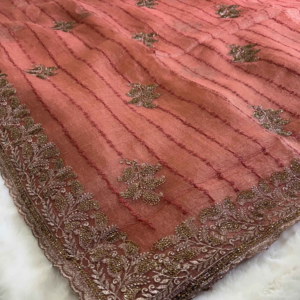 Pink fabric with gold embroidery on a white background