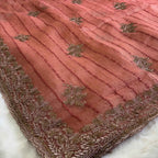 Pink fabric with gold embroidery on a white background