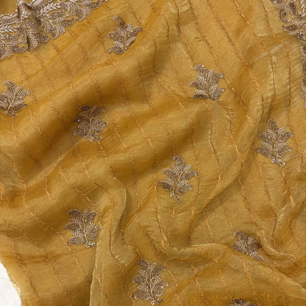 Close-up of gold fabric with silver leaf embroidery