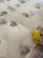 Delicate fabric with floral embroidery and a yellow flower on a light background