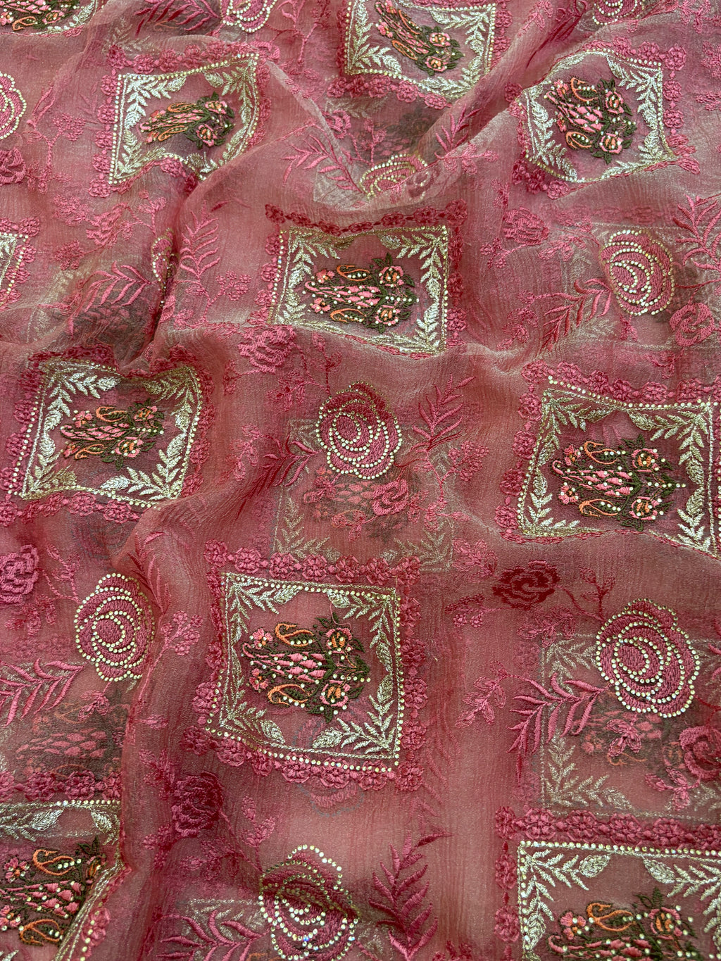 Pink embroidered fabric with intricate patterns