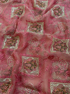 Pink embroidered fabric with intricate patterns
