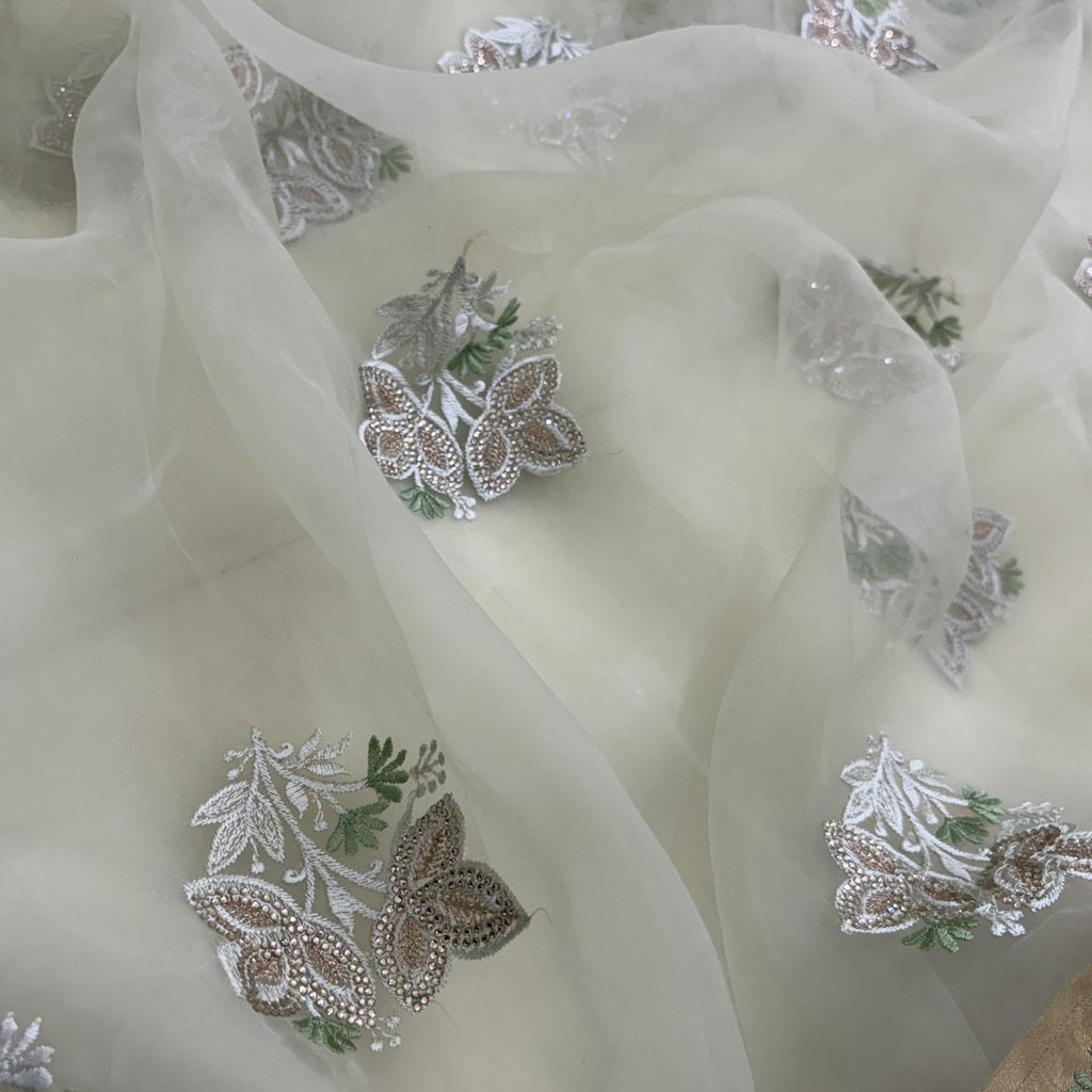 Close-up of embroidered fabric with butterflies and floral patterns on a sheer background